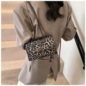 Detailed close-up of leopard print shoulder bag with metallic stud accents and chain strap