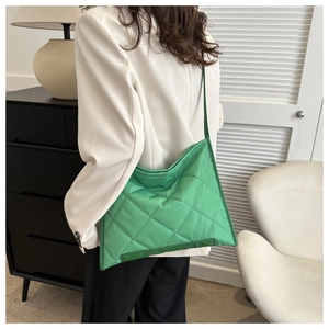 Grass green quilted tote bag with diamond stitching shown on a person for size perspective