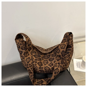 Detail of large leopard print tote bag with wide strap on a modern display surface