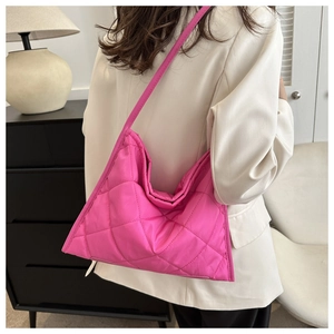 Detailed back view of a hot pink quilted tote bag worn over a white blazer