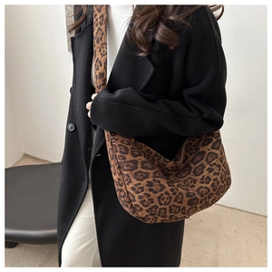 Detail view of large leopard print tote bag styled with a minimalist black coat