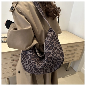 Detail view of large leopard print hobo bag worn with a khaki trench coat for autumn style