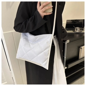 Close-up of white quilted nylon crossbody bag with rhombus stitching and slim strap