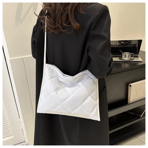 Detailed view of white quilted rhombus pattern on a large capacity shoulder tote bag