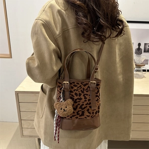 Retro leopard print bucket bag with plush bear charm and brown leather handle strap