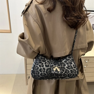 Modische Schultertasche mit Leopardenmuster und goldener Schleife zum khakifarbenen Mantel
