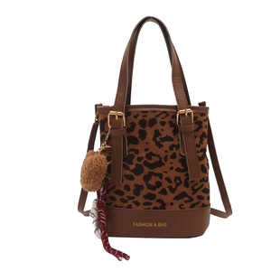 Leopard print tote bag with brown faux fur and detachable strap on white background