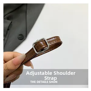 Détail de la bandoulière réglable en cuir marron avec boucle argentée et coutures fines
