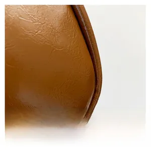 Gros plan sur la texture en similicuir marron foncé huilé avec coutures incurvées