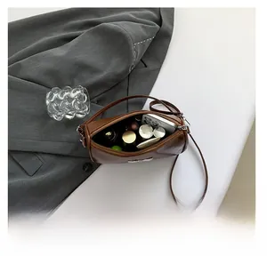 Vue intérieure du sac bandoulière en cuir marron montrant le rangement pour maquillage