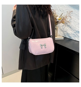 Vue détaillée d'un petit sac bandoulière rose avec un nœud décoratif en métal argenté