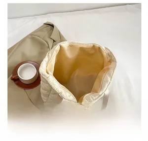 Top view of spacious interior and zipper closure on cream quilted nylon tote bag
