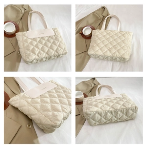 Detail view of cream quilted nylon tote bag with leather trim and fashion logo