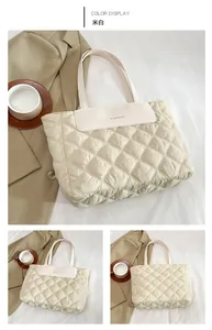 Detail of quilted nylon tote bag in cream white with FASHION leather patch and stitching
