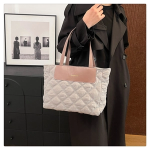 Close-up of quilted tote bag with pink leather panel and FASHION lettering detail
