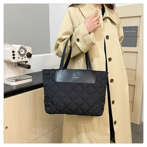 Close-up of black quilted nylon tote bag with Fashion lettering and twin top handles