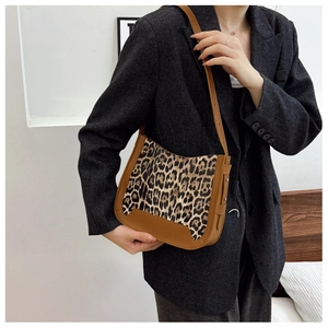 Sac bandoulière léopard tendance porté par un mannequin avec détails en cuir brun