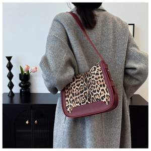 Model wearing vintage leopard print and burgundy leather tote bag with gray wool coat