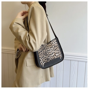 Détail du sac hobo à motif léopard avec bordure en cuir noir et fine bandoulière chic