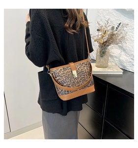 Fashionable leopard print bucket bag for women styled with a black sweater in an interior