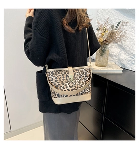 Chic leopard print bucket bag styled by a model in a minimalist interior setting