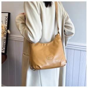Model view of a mustard yellow tote bag styled with a beige coat for a minimal look