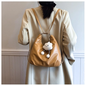 Minimalist camel PU leather hobo bag with cloud charm worn by a model in a beige blazer