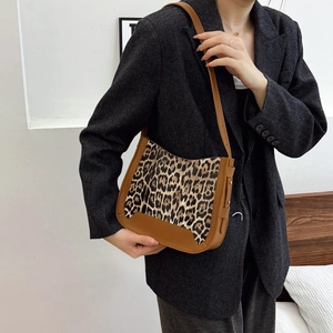 Sac bandoulière imprimé léopard avec bordure en cuir marron sur blazer gris
