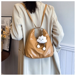 Detail of caramel PU leather hobo tote with plush cloud charm and embossed label