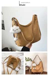 Detail view of khaki faux leather tote bag with white fluffy cloud pendant and chain strap