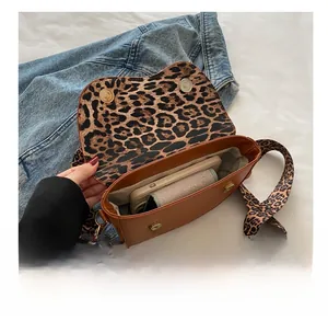 Brown leather saddle bag interior showing leopard print lining and phone capacity