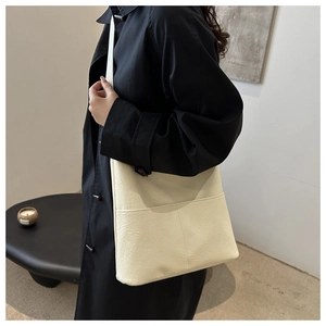 Détail du sac à bandoulière en similicuir crème avec poche frontale en situation réelle