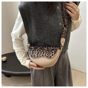 Detail of saddle bag showing stylish leopard print wide strap and gold hardware accents