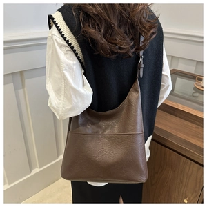 Detail of coffee brown leather tote bag with stitch textures and adjustable strap