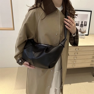 Large black lychee pattern leather crescent dumpling bag shown on a model in trench coat