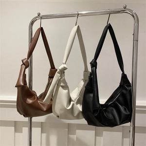 Chic ruched croissant bag in brown, white and black colors with knot shoulder strap detail