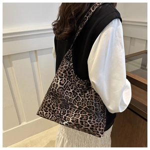 Side view of trendy leopard print tote bag styled on a model in a modern interior