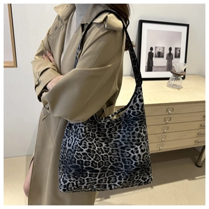 Detail of trendy leopard print tote bag styled with a khaki trench coat for a chic look