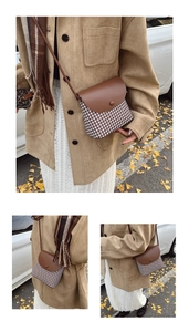 Detail of a vintage houndstooth crossbody bag with brown leather flap in a street setting