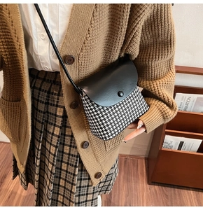 Detail of retro houndstooth crossbody bag with black leather flap and button closure