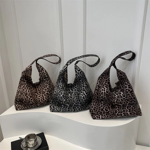 Three trendy leopard print tote bags in various colors on a white display stand