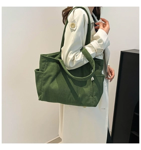 Detail of forest green corduroy tote bag showing side pocket and textured fabric finish