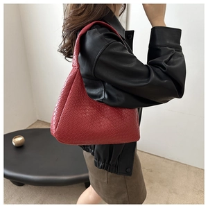 Gros plan d'un sac hobo en cuir tressé rouge montrant le motif de texture Intrecciato