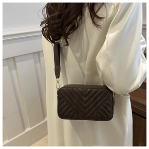 Close-up of vintage dark brown quilted square crossbody bag with V-shaped texture