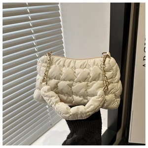 Close-up of quilted white cloud handbag with golden chain and pleated handle detail