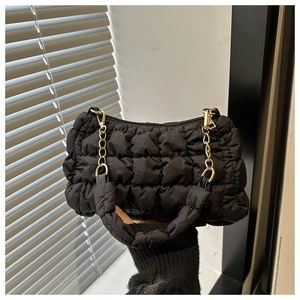 Detailed close-up of quilted puffy cloud bag with chunky gold chain and padded handle