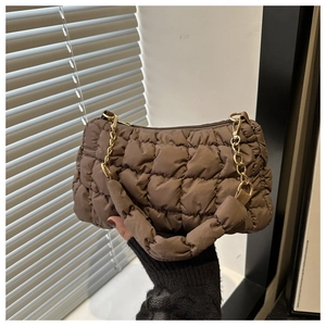 Detail of a brown quilted bubble hobo bag with gold chain strap and padded texture