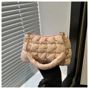 Detailed shot of pink quilted puffy bag with golden chain strap and padded handle texture