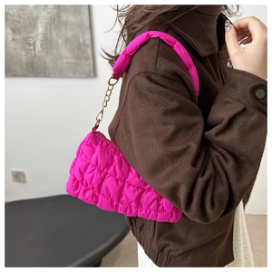 Detail of rose pink quilted cloud bag with puffy texture and gold chain strap link