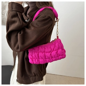 Macro shot of hot pink quilted bubble handbag with metallic chain and soft puffy texture